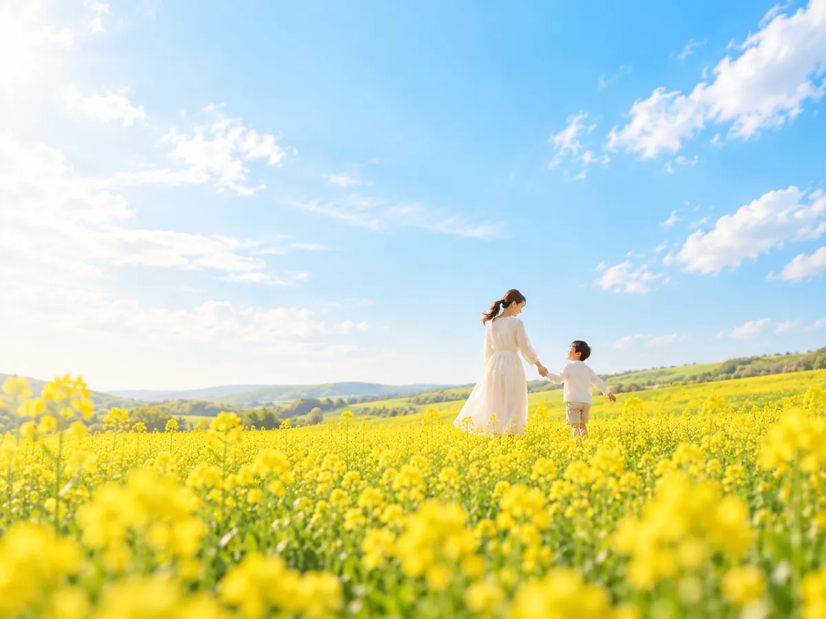 青空と黄色い花畑で大人と子どもが手をつなぐ、つながりを表したイメージ画像。